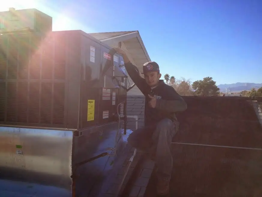 HVAC technician performing AC Tune-Up on a rooftop unit in Newburyport